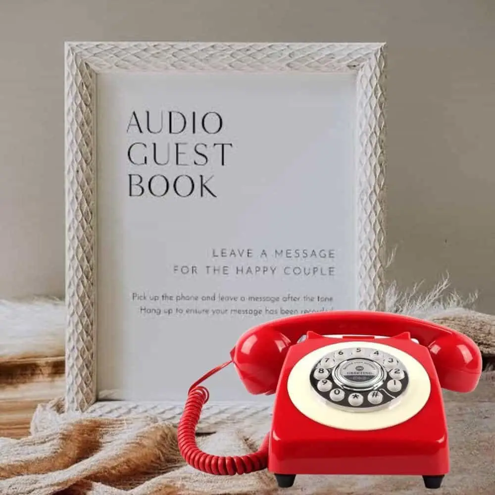 Telefon retro roșu Classic50 Red lângă o ramă cu instrucțiunile Audio Guest Book