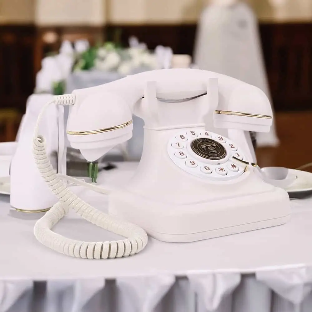 Telefon retro alb Elegance70 White pe o masă cu față de masă albă